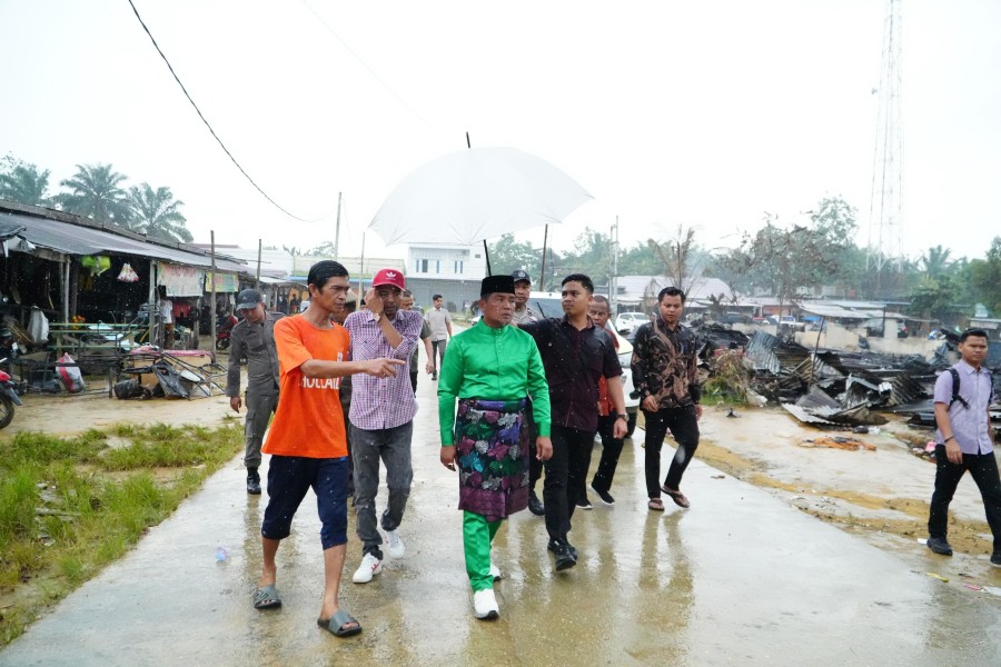 Dalam Kondisi Hujan Bupati Pelalawan Tinjau Lokasi Kebakaran Pasar Kuala Semundem Dan Salurkan Bantuan