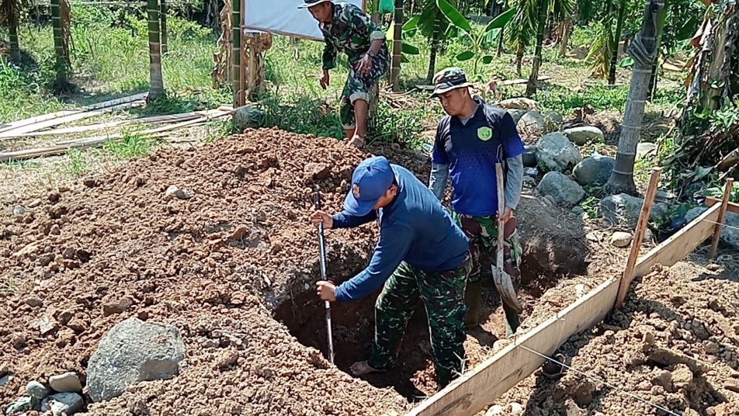 Terik Matahari Tak Surutkan Semangat Satgas TMMD 129 Kodim 0102/Pidie Gali Septic Tank untuk Bangun MCK di TPU Blang Cot