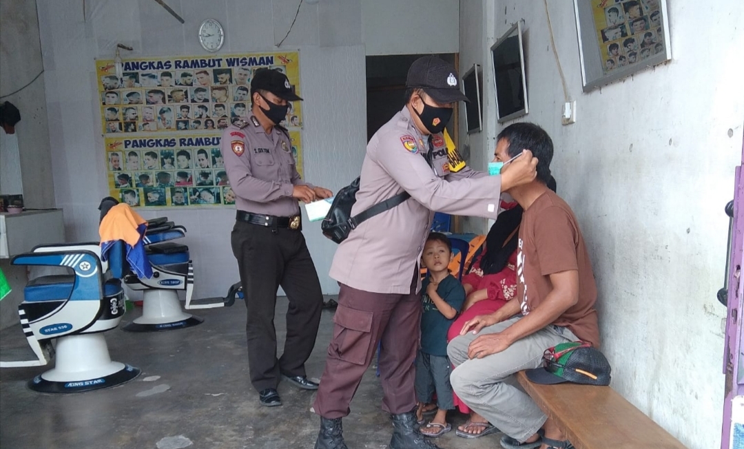 Ajak Masyarakat Tetap Patuhi Prokes, Sejumlah Personil Polsek Bunut Bagi Masker Gratis